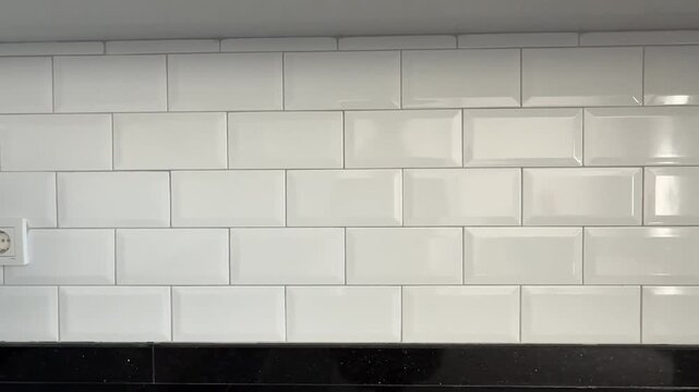 White subway tile kitchen wall with electrical outlet serves as modern interior background