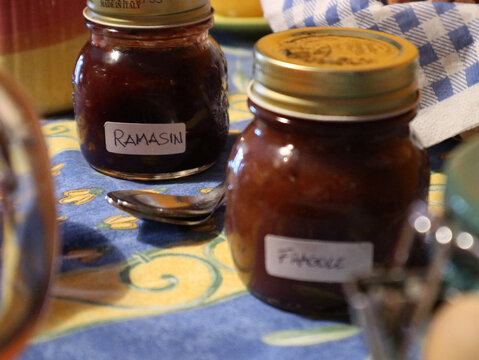 Due barattoli di marmellata fatta in casa con etichette scritte a mano posati su una tavola da colazione in stile rustico, confettura artigianale di frutta per un risveglio genuino