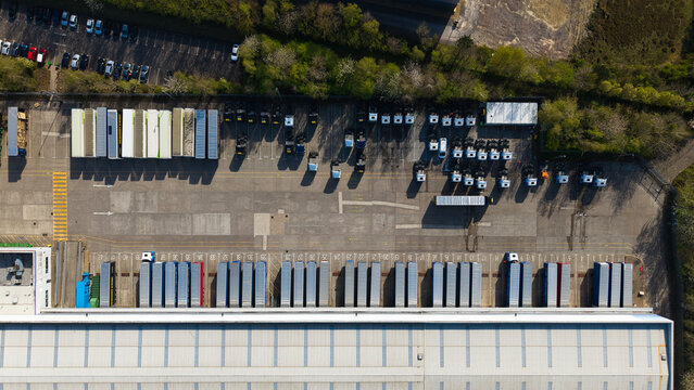 Aerial view of the industrial warehouse and logistics distribution center with semi-truck trailers parked at loading bays Magna Park, England, United Kingdom.