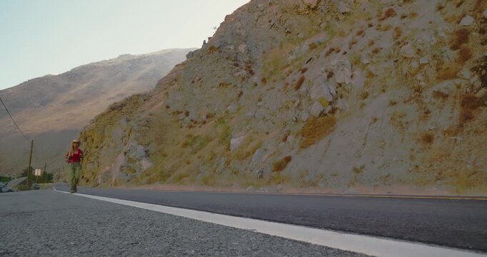 Woman Hiking on Mountain Road in Desert Landscape