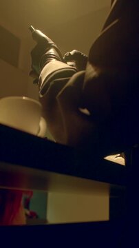 Closeup of skilled shoemaker stitching and polishing footwear with care, Detailed scene of shoe craftsman meticulously repairing and polishing leather boot under gentle lamp illumination Vertical