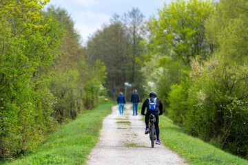 Fototapeta premium Radfahrer und Füßgänger am Donau-Damm im Frühjahr