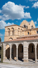 Fototapeta premium Fotografía vertical campanario y arcada de la basílica de los hermanos santos Vicente, Sabina y Cristeta de estilo románico en Avila, España. Con cielo editado
