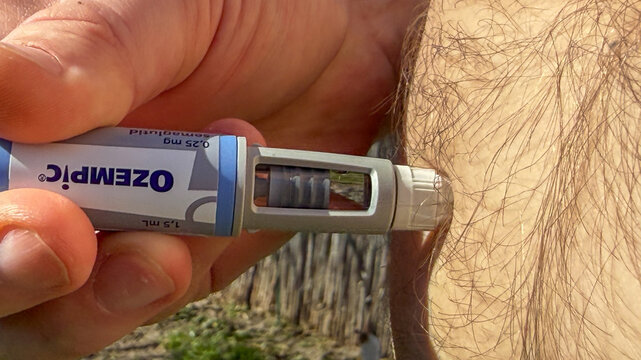 Outdoor closeup of adult Caucasian male self-injecting Ozempic pen in daylight, for editorial and patient education, Semaglutide, Novo Nodrisk, GLP-1 March 5 2026, Subotica, Serbia