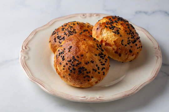 Traditional Turkish Homemade Pogaca Pastries with Nigella Seeds on a Vintage Plate