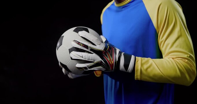 Gloved keeper gripping soccer ball, starting spin overlay, rotating and catching for warmup