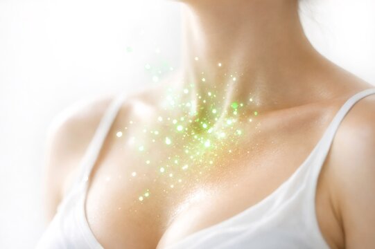 Woman's neck and chest showing glowing green particles, symbolizing concepts of health, wellness, vitality, alternative medicine, healing, and spiritual well being