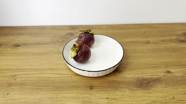 Horizontal close-up video of fresh mangosteen fruit. Exotic tropical fruit with purple rind and white segments