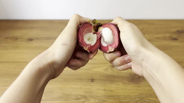 Horizontal close-up video of fresh mangosteen fruit. Exotic tropical fruit with purple rind and white segments