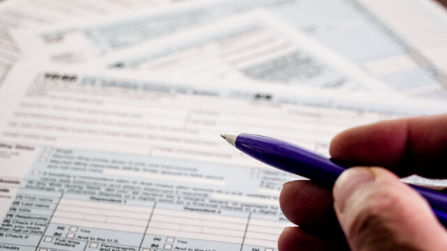 Hand filling out us tax form 1040 document