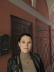 Fototapeta premium Portrait of woman in historic Italian corridor with decorative iron gate