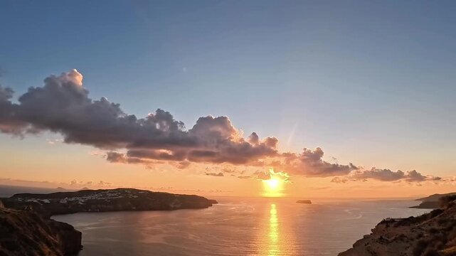 Stunning time-lapse of a golden sunset over the volcanic caldera of Santorini, Greece. The video shows the sun disappearing behind clouds and the horizon, reflecting on the Aegean Sea with a vibrant o