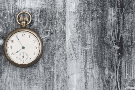 Vintage pocket watch on grunge wood background