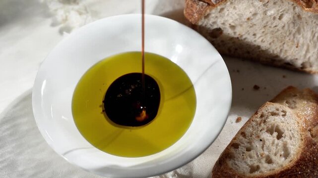 Balsamic vinegar swirling in a bowl of olive oil