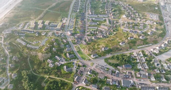 Aerial view of the Sylt coastline with its sandy beach, golf course and adjacent residential area, showing a contrast of colors and textures, Sylt, Schleswig-Holstein, Germany.
