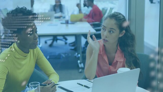 Two women opening laptop pointing, noting, dotted map and terminal scrolling on glass in IT meeting