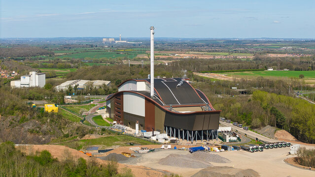 Aerial view of Encyclis Newhurst ERF, a modern energy recovery facility with a tall stack and curved roofline set against a rural landscape in Shepshed, England, United Kingdom.