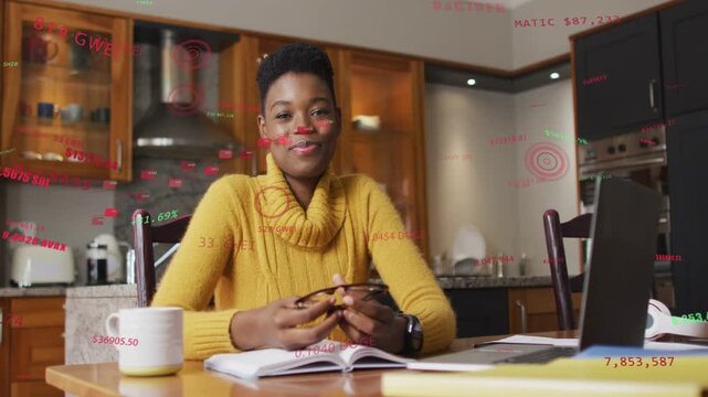 Woman studying at table reacting to laptop ping laughing smiling adjusting glasses red layer moving