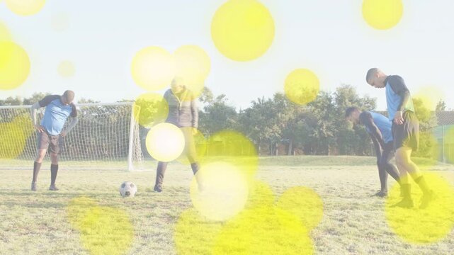 Coach stepping to ball tapping starting soccer drill team shifting yellow bokeh hovering overhead