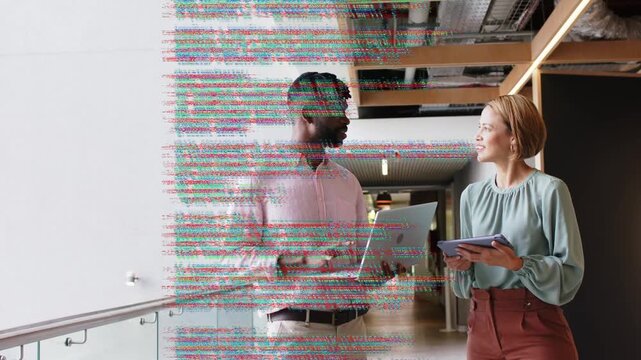 Tech colleagues viewing code on laptop and tablet, noise causing overlay obscuring, clearing