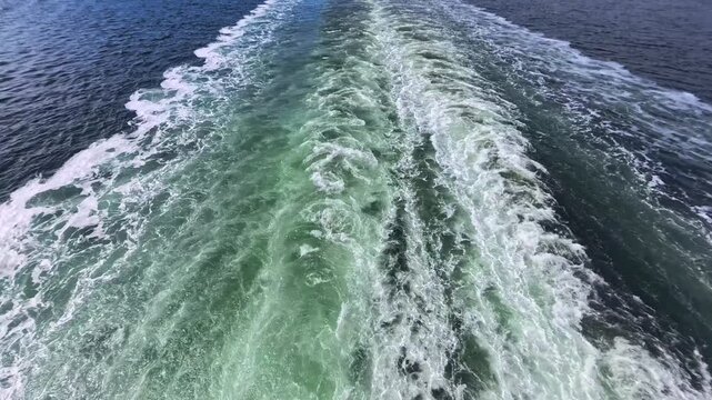 August 13, 2024 - Tracy Arm, USA - Boat wake creates a pattern in the water along Tracy Arm waterway. The boat cuts through the water leaving the foamy trail behind it.