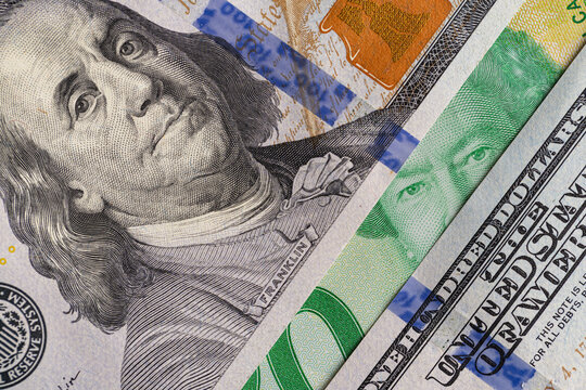 US hundred dollar bill and Canadian twenty dollar banknote close up