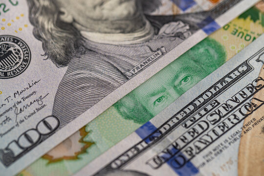 US hundred dollar bill and Canadian twenty dollar banknote close up