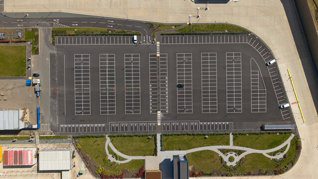 Aerial view of a supermarket distribution centre parking lot with white bay markings and landscaped green areas in Nailstone, Nuneaton, United Kingdom.