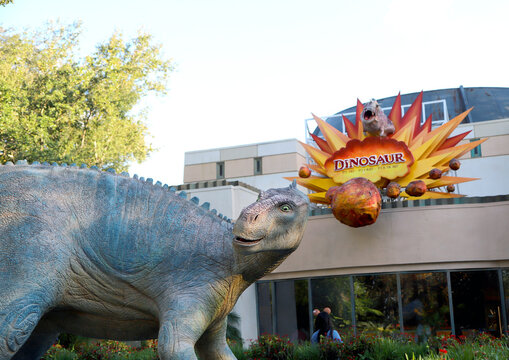 Facade of the Dinosaur attraction in a theme park with a dinosaur sculpture in front