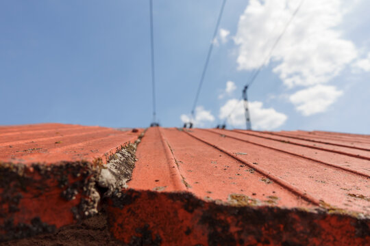 Red tiled roof with power lines against blue sky in Gniezno Poland