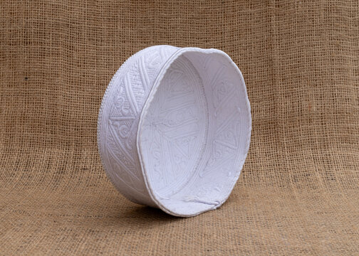 White Traditional Muslim Prayer Cap with on Burlap Background