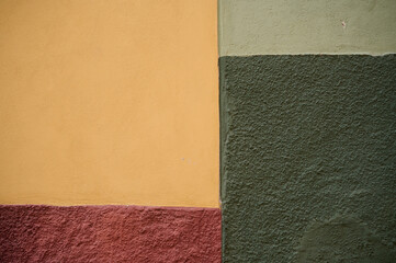 Fototapeta premium A colorful wall section in San Miguel de Allende, Guanajuato, Mexico, showcasing textured surfaces and vibrant painted areas with distinct regional architectural character.