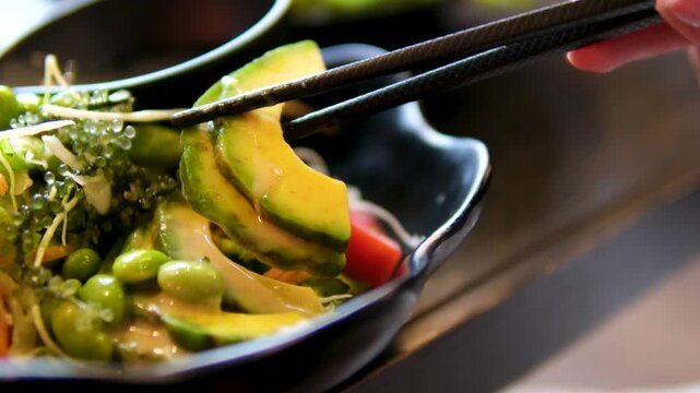 Poke bowl with salmon, rice, avocado, edamame beans, cucumber and radish in gray bowl. Hawaiian ahi poke bowl, gray background.