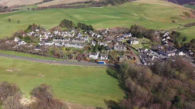 Scenic perspective of a traditional Scottish village landscape featuring quaint stone houses and vibrant natural surroundings in Eddleston
