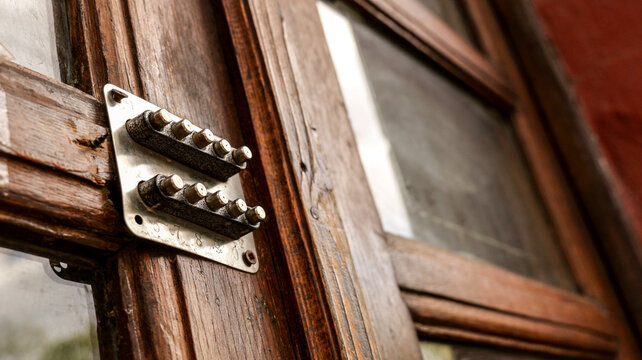 Close-up of an old mechanical keypad lock on a weathered wooden door