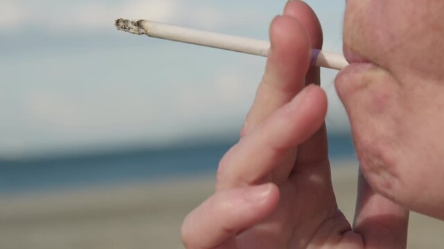 Woman smoker smokes cigarette, close-up, side view, harm to health, unhealthy lifestyle, bad habit