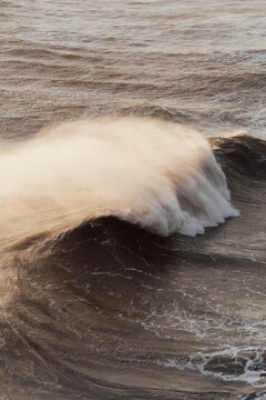 Large crashing ocean wave in natural photographic style over open water background, concept of power and nature. Nazar&eacute;, Portugal