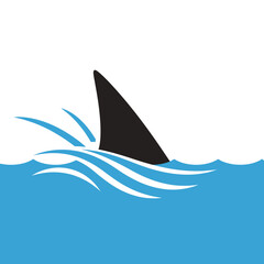 Fototapeta premium Shark fin emerging from ocean waves.