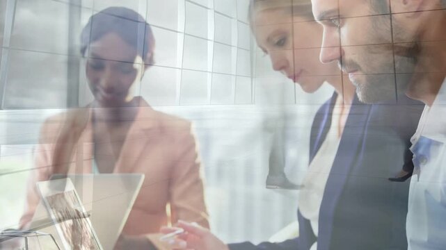 Vertical video: Camera pulling back, three colleagues leaning, typing and noting to complete task