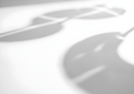Blurred gray shadows on a white surface with abstract shapes and lines