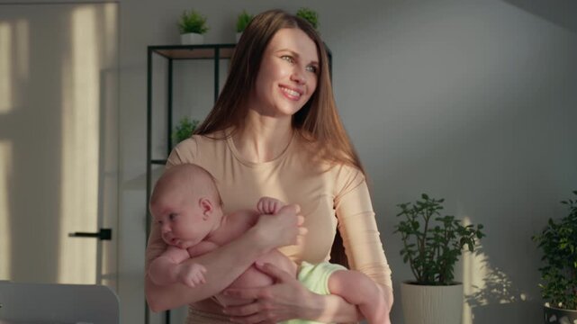 Woman cradles newborn baby in arms gentle sunlight illuminates scene with soft shadows plants background promoting bonding affection comfort and care. Infant child family love parenthood cozy home