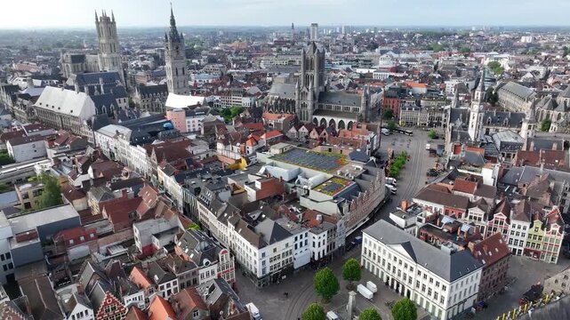 Aerial drone view of Ghent old town in Belgium, with the towers of St. Nicholas and St. Michael's Churches and Castle of the Counts next to river Lys. Architecture and landmarks of the medieval city.