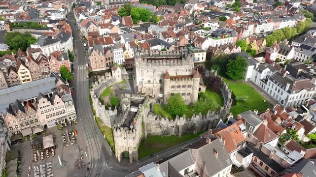 Aerial drone view of Ghent old town in Belgium, with the towers of St. Nicholas and St. Michael's Churches and Castle of the Counts next to river Lys. Architecture and landmarks of the medieval city.