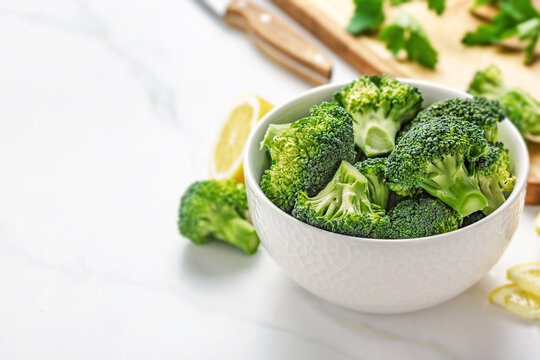 Fresh broccoli florets in bowl with lemon
