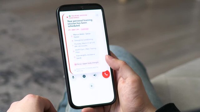 Personal training session confirmed on a smartphone app. Screen displays workout details and trainer info. Perfect for fitness marketing, lifestyle booking, and wellness tech. High-converting footage