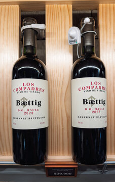 Santiago, Chile, March 09, 2026, Los Compadres, Baettig, glass bottle, 0,75 l, bottles of Cabernet Sauvignon red wine on a wooden display shelf in a retail store.