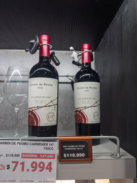 Santiago, Chile, March 09, 2026, Concha y Toro Carm&iacute;n de Peumo, glass bottle, 0,75 l, bottles of red wine displayed on a retail shelf with price tags and security tags.