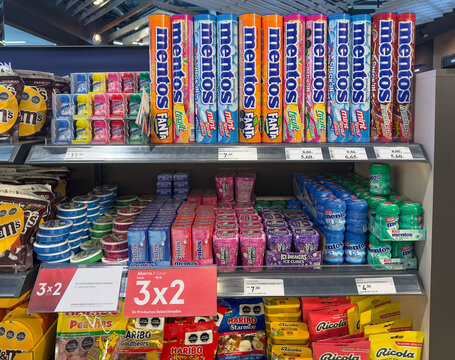 Santiago, Chile, March 15, 2026, Mentos and Haribo, assorted candy, gum, and mint products on a supermarket shelf with promotional pricing signs.