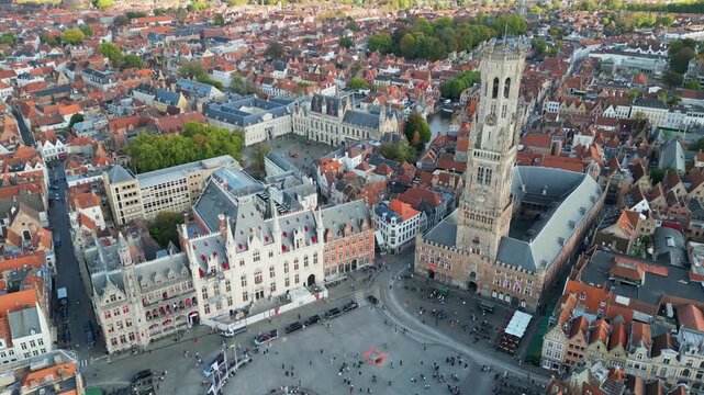 Aerial drone footage of the historic Markt square in Bruges, Belgium. Featuring the medieval Belfry tower (Belfort), colorful guild houses, and the Provincial Court building . Version 2.