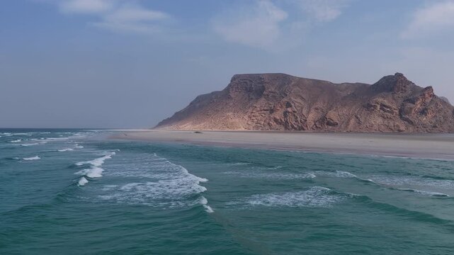 Aerial view of a remote sandy beach with turquoise ocean waves, socotra island
